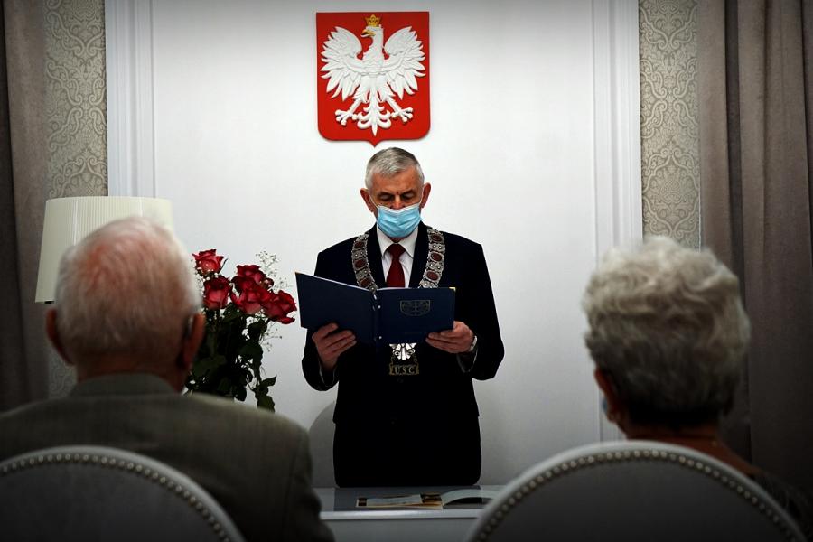 Na zdjęciu widać trzy osoby, dwie siedzą odwrócone plecami