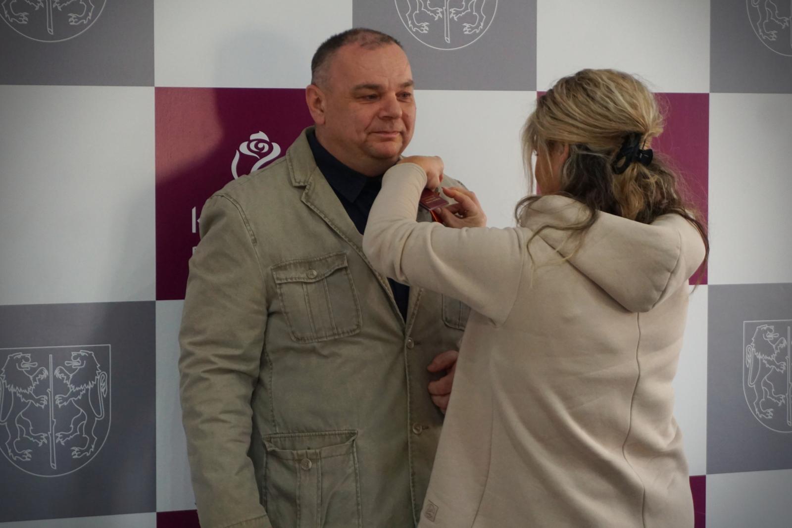 Robert Feliniak odbiera odznaczenie z rąk przedstawicielki RCK