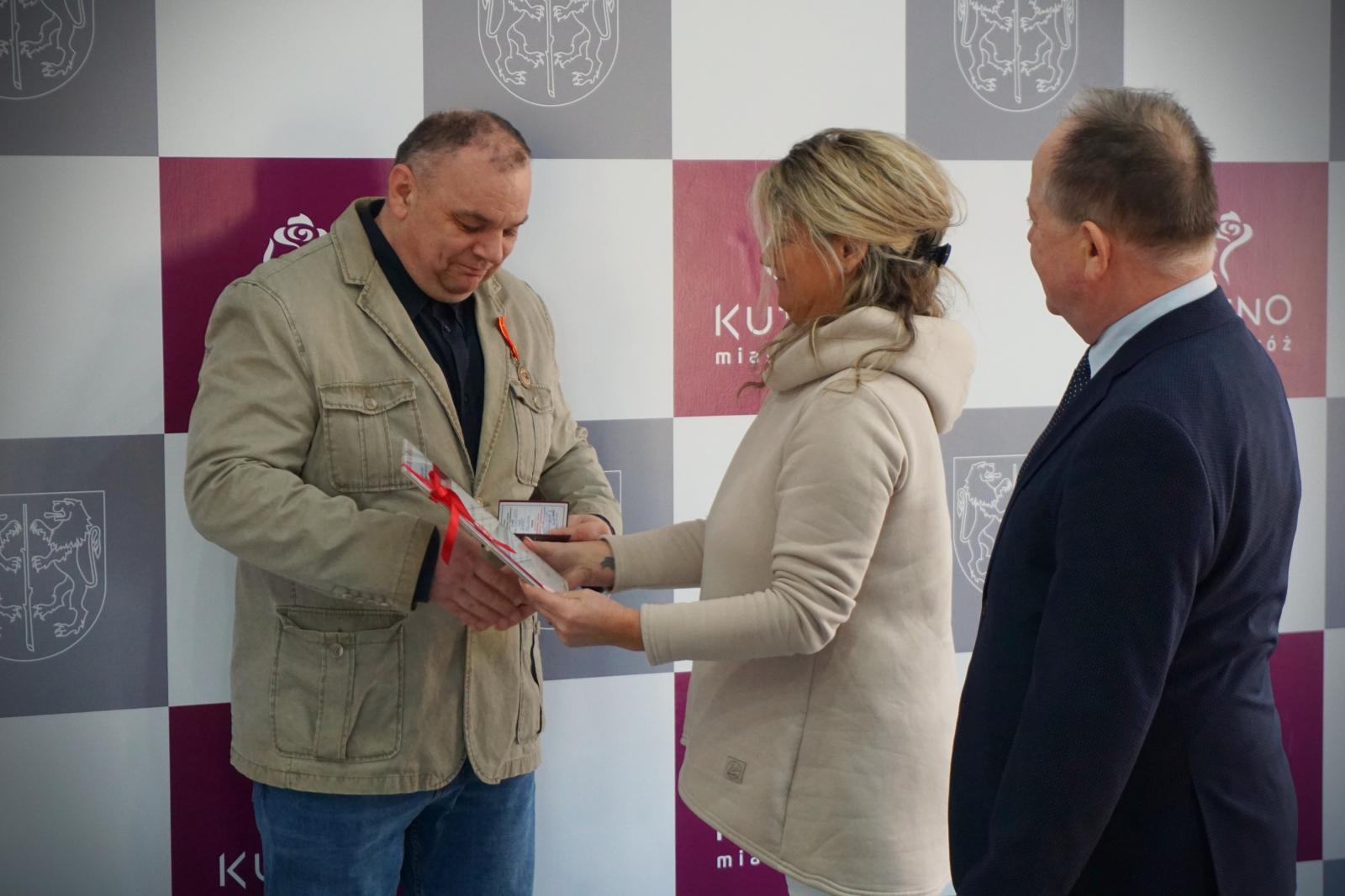 Robert Feliniak odbiera odznaczenie z rąk przedstawicielki RCK