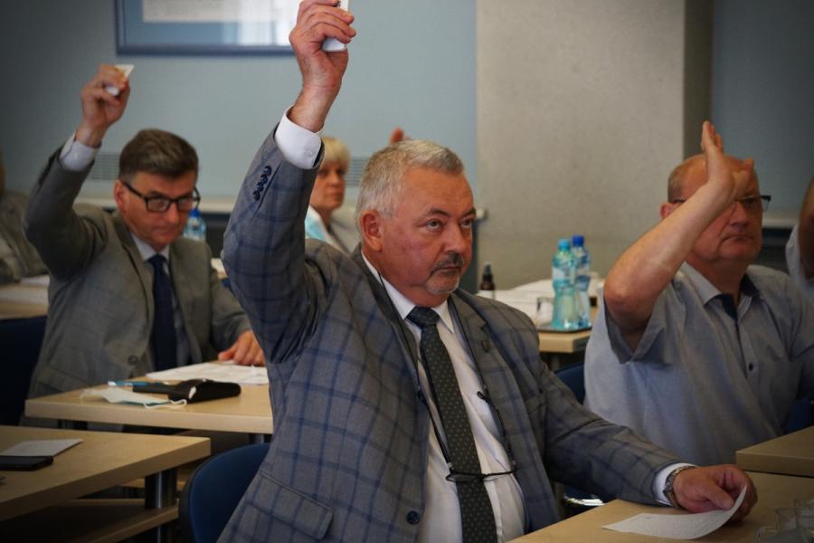 Na zdjęciu widać czworo radnych głosujących podczas sesji