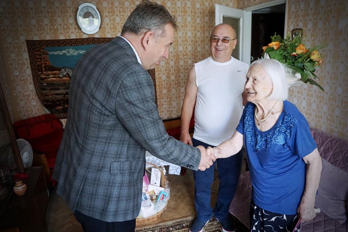 Na zdjęciu widać dwie osoby skłądające życzenia jubilatce
