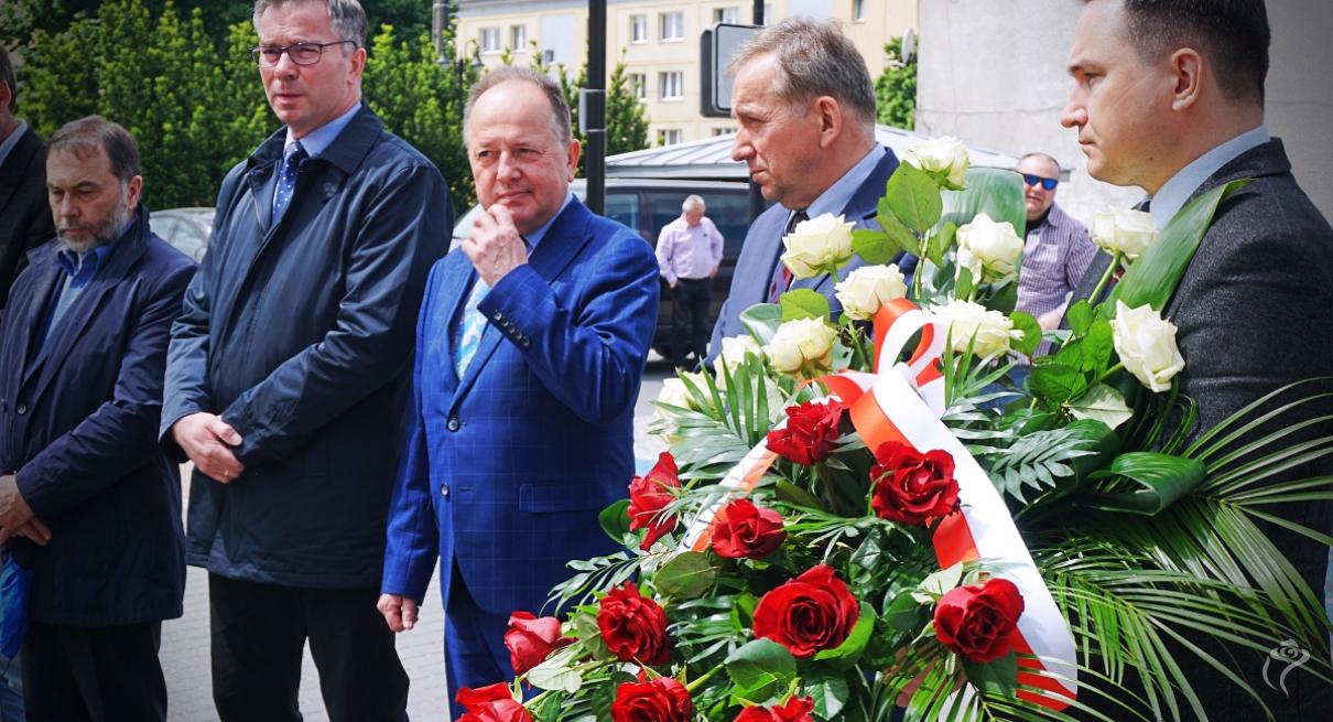 Na zdjęciu widać pięć osób, jedna trzyma kwiaty