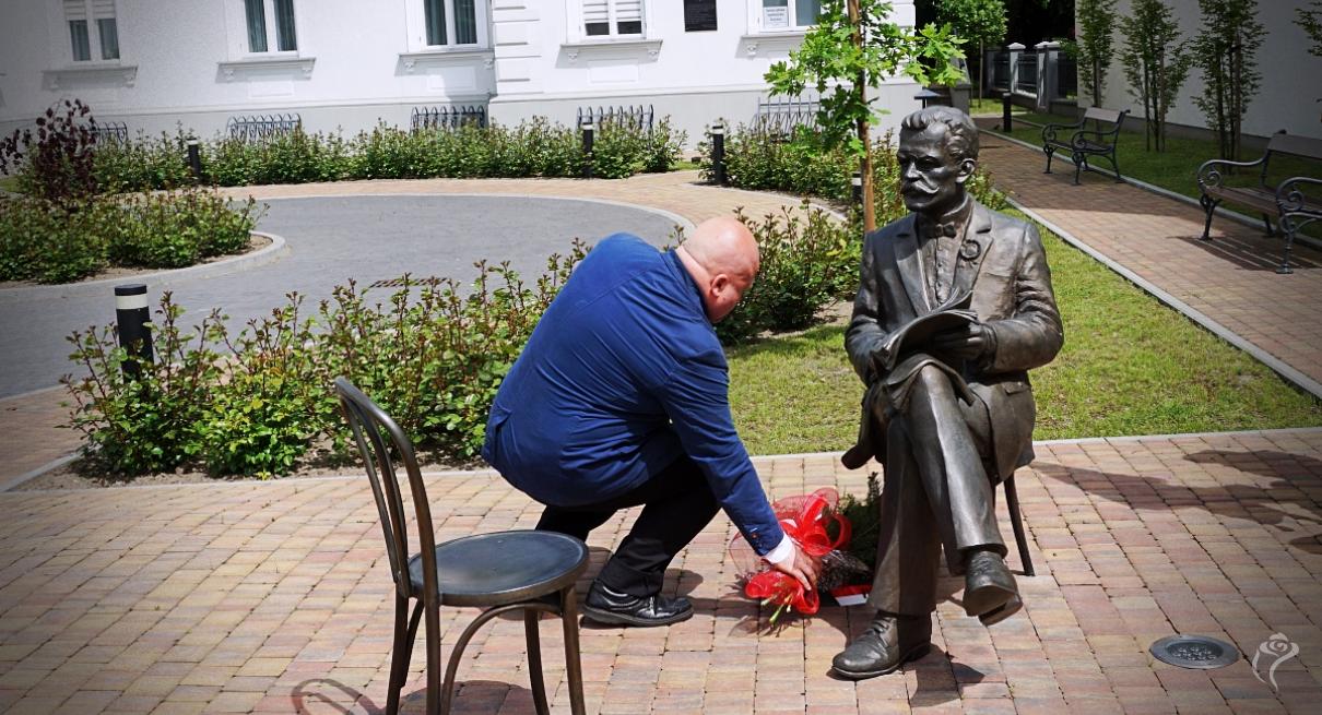 Na zdjęciu widać osobę składającą kwiaty