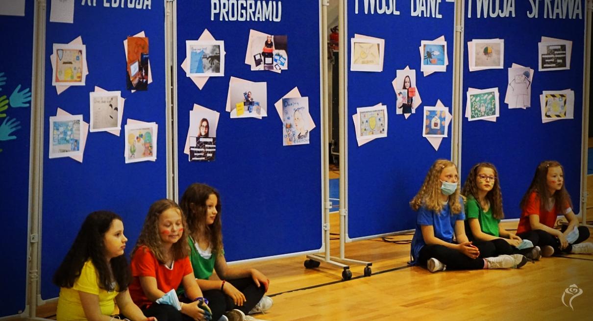 Na zdjęciu widać sześcioro dzieci siedzących na podłodze
