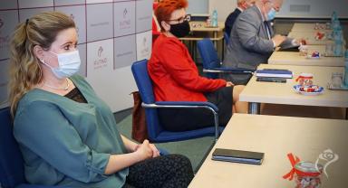 Na zdjęciu widać cztery siedzące osoby, na pierwszym planie dwie kobiety