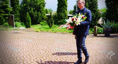 Na zdjęciu widać jedną osobę niosącą kwiaty