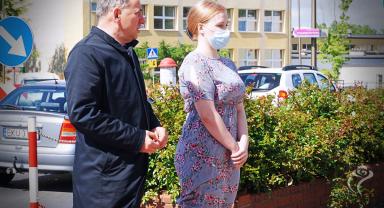 Na zdjęciu widać dwie osoby, jedna w masce