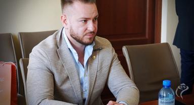 Na zdjęciu widać jedną osobę siedzącą przy stole