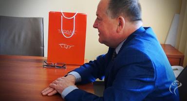 Na zdjęciu widać jedną osobę siedzącą przy stole