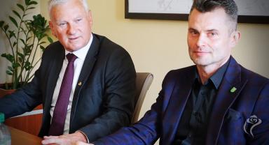 Na zdjęciu widać dwie osoby siedzące przy stole