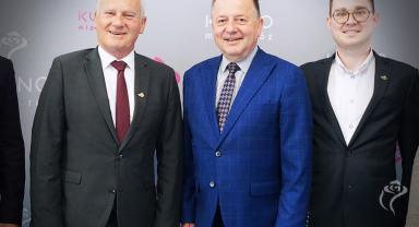 Na zdjęciu widać trzy osoby stojące obok siebie
