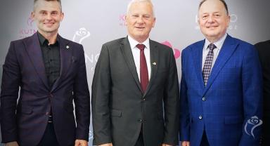 Na zdjęciu widać trzy osoby stojące obok siebie
