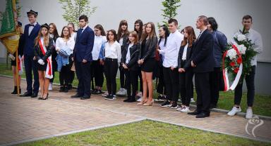 Na zdjęciu widać kilkanaście osób stojących podczas 