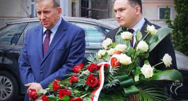 Na zdjęciu widać dwie osoby, jedna trzyma kwiaty