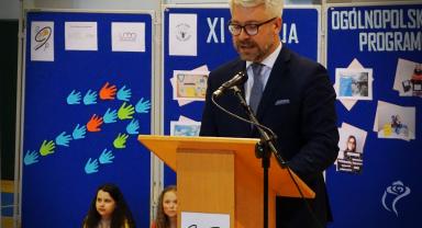 Na zdjęciu widać jedną osobę przemawiającą na mównicy