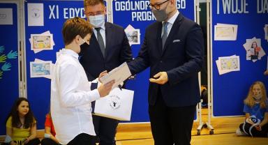 Na zdjęciu widać laureata nagrody odbierającego gratulacje od dwóch osób