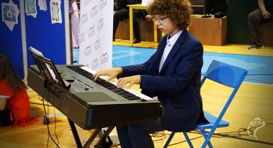 Na zdjęciu widać ucznia szkoły grającego na organach 