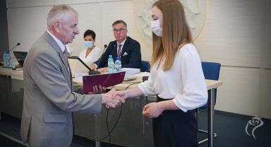 Na zdjęciu widać dwie osoby podczas nagradzania 