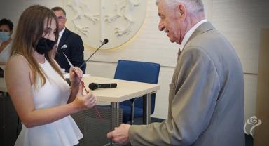 Na zdjęciu widać dwie osoby podczas nagradzania 