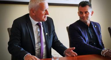 Na zdjęciu widać dwie osoby siedzące przy stole