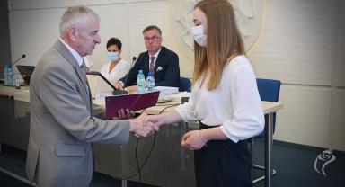 Na zdjęciu widać dwie osoby podczas nagradzania 
