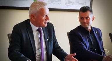 Na zdjęciu widać dwie osoby siedzące przy stole