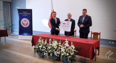 Na zdjęciu widać moment przekazania symbolicznego czeku na dofinansowanie