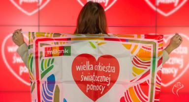 Wolontariuszka z flagą Wielkiej Orkiestry Świątecznej Pomocy
